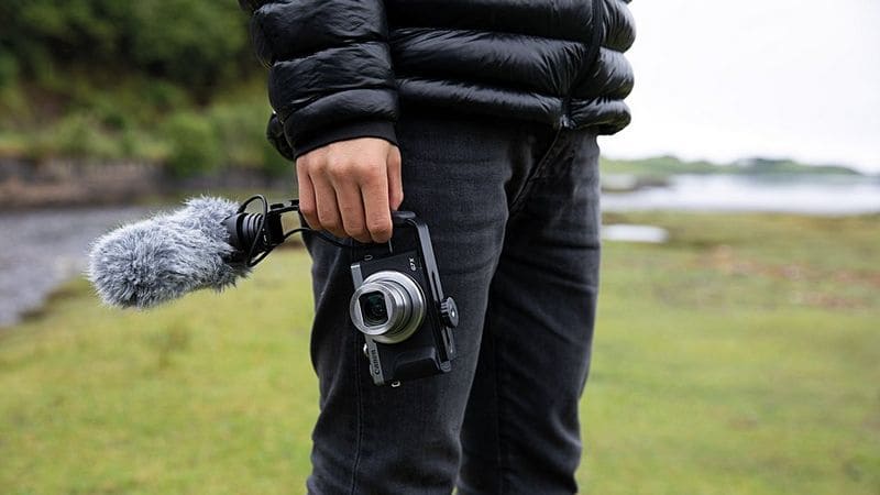 a person carrying a canon powershot G mark III