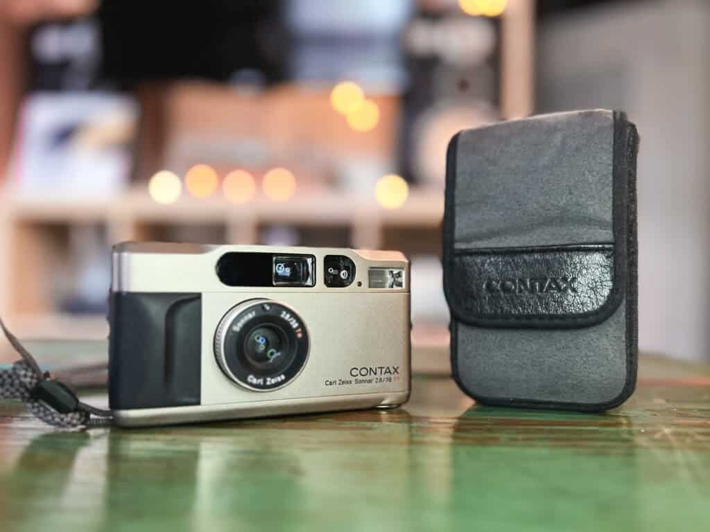 mini contax camera placed on a shiny surface with a black pouch 