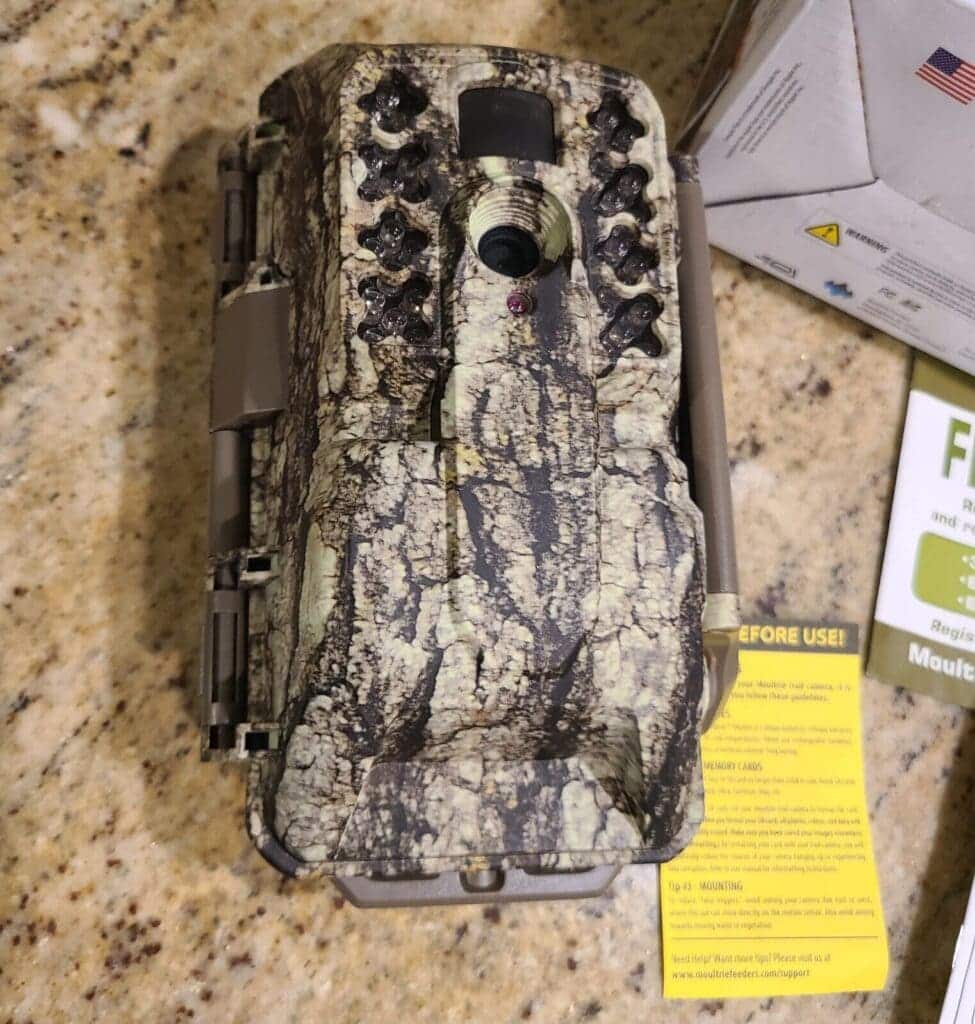 moultrie cellular trail camera placed on a desk with instructions