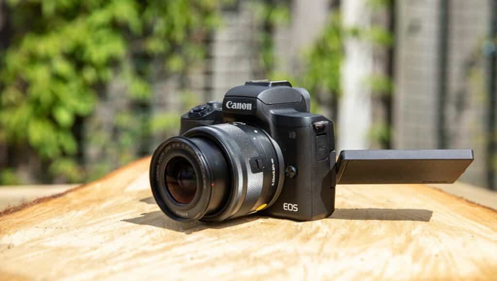 small canon Mark II camera placed on a wooden surface in sunlight