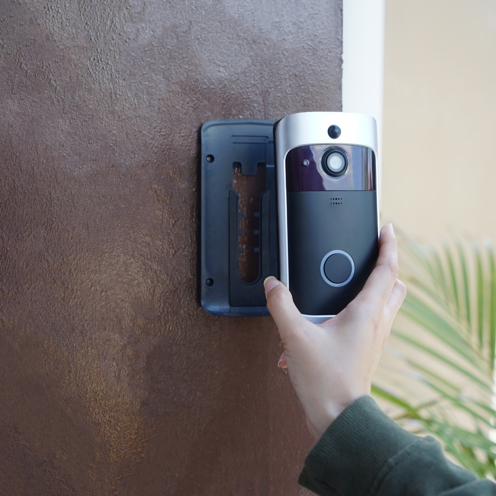 Close Up Of Hand Ringing Front Doorbell Equipped With Security